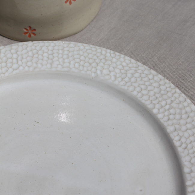 Sa forme classique et sa couleur blanche intemporelle en font un élément polyvalent qui peut s'adapter à de nombreux styles de table. La texture légèrement granuleuse ajoute une touche d'originalité et de sophistication.