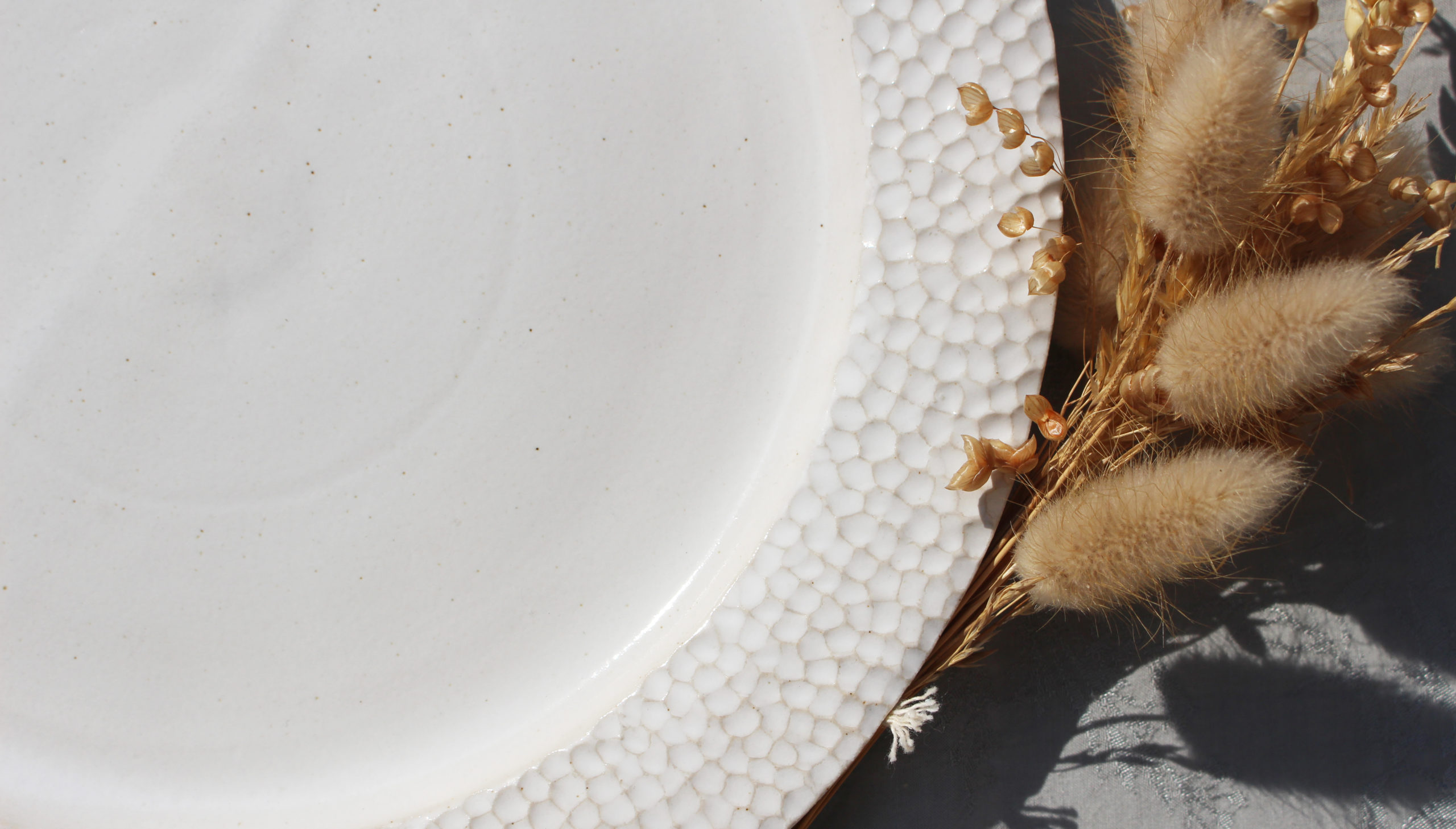 Assiette blanche en céramique, détail poinçonnage sur les contours