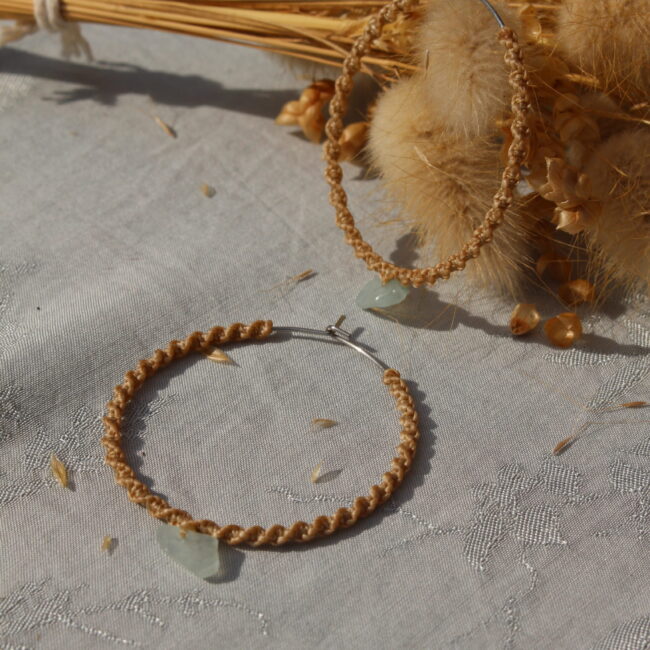 Ces créoles allient à la fois un style bohème et moderne. Le macramé apporte une touche artisanale et naturelle, tandis que la forme circulaire et la pierre en semi-précieuse