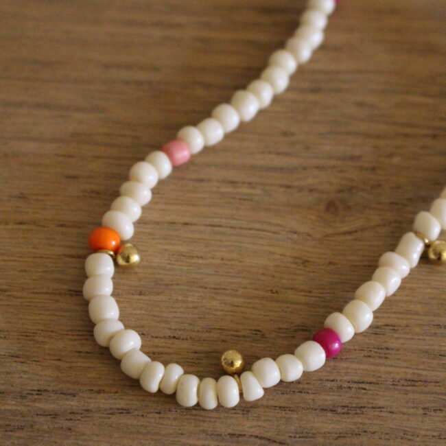 Collier en perle, structure en acier inoxydable doré. Perles en plastique blanche, fushia, rose et orange
