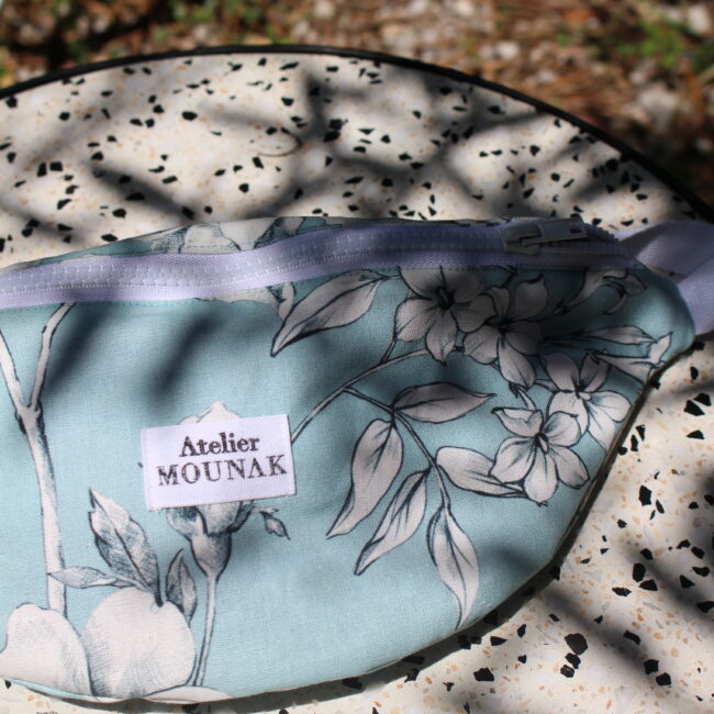 La banane fleurs blanches. Accessoire mode incontournable pour un look décontracté et urbain. Confectionné un tissus de seconde main doux et résistant.